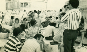 Dr. Ed Best lecturing on the Acropolis, Athens, Greece in front of the Parthenon,with a view of the Erectheum. 1970. 